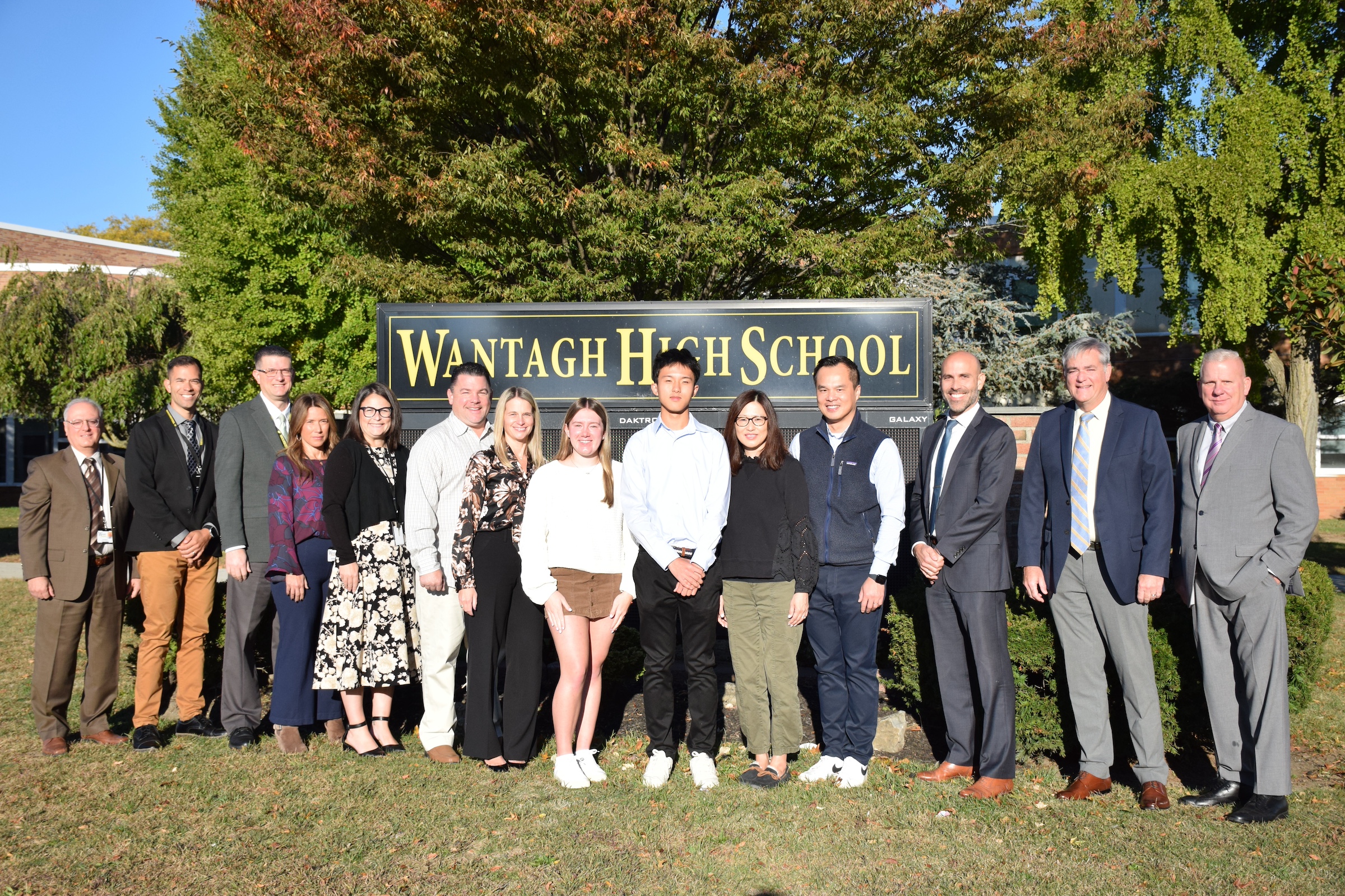 people standing in front of school marquee
